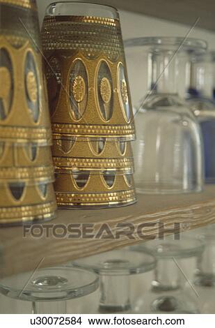 Metallic gold teaglasses on wooden shelf View Large Photo Image Picture - Metallic gold teaglasses on wooden shelf. Fotosearch