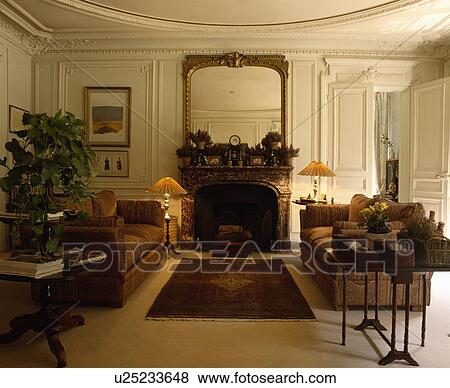 Mirror above fireplace in cream panelled traditional living room View Large Photo Image Stock Photo - Mirror above fireplace in cream panelled traditional living room. Fotosearch