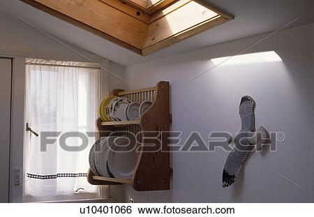 Stock Photograph - Model seagull on wall beside pine plate rack. Fotosearch