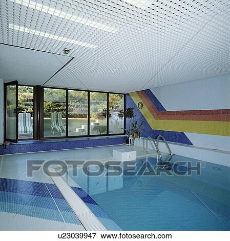 Modern indoor swimming pool with tiled mural View Large Photo Image Stock Photo - Modern indoor swimming pool with tiled mural. Fotosearch