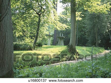 Modern sculpture in woodland with winding path through trees View Large Photo Image Stock Photo - Modern sculpture in woodland with winding path through trees. Fotosearch