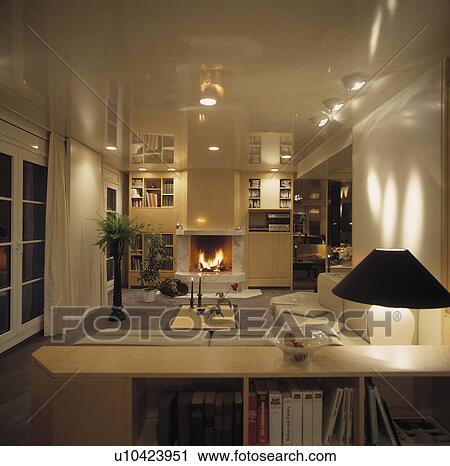 Stock Image - Modern white living room lit at night. Fotosearch
