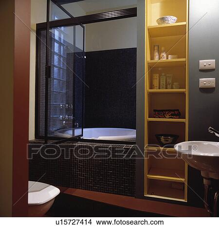 Narrow yellow shelves beside glass swivel door to bath in modern bathroom View Large Photo Image Picture - Narrow yellow shelves beside glass swivel door to bath in modern bathroom. Fotosearch
