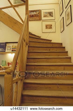 Stock Image - Old pine stairs and bannisters on cream staircase. Fotosearch