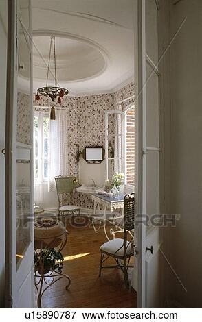 Stock Photo - Open double doors to traditional white dining room with circular ceiling detail and wooden flooring. Fotosearch