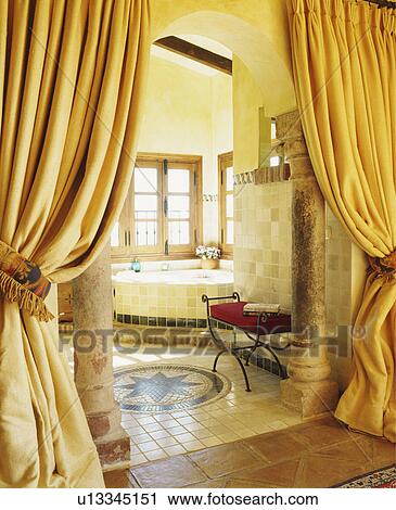 Opulent curtains and stone pillars at entrance to Spanish bathroom with mosaic pattern on tiled floor View Large Photo Image Stock Image - Opulent curtains and stone pillars at entrance to Spanish bathroom with mosaic pattern on tiled floor. Fotosearch