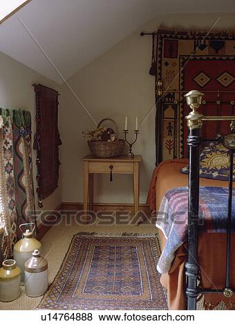 Oriental rug on sisal carpet in cottage bedroom with brass bed and earthenware casks View Large Photo Image Stock Photo - Oriental rug on sisal carpet in cottage bedroom with brass bed and earthenware casks. Fotosearch