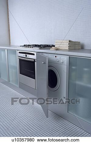 Oven beside open kitchen unit door on fitted dishwasher in modern kitchen View Large Photo Image Stock Image - Oven beside open kitchen unit door on fitted dishwasher in modern kitchen . Fotosearch