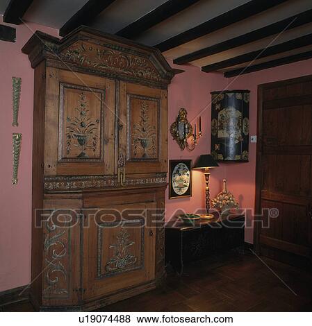 Painted antique cupboard in pink cottage hall with lighted lamp on small table View Large Photo Image Stock Photo - Painted antique cupboard in pink cottage hall with lighted lamp on small table. Fotosearch
