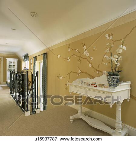 Painted orchid on neutral wall on landing with white orchid in pot on cream painted console table View Large Photo Image Stock Photo - Painted orchid on neutral wall on landing with white orchid in pot on cream painted console table. Fotosearch