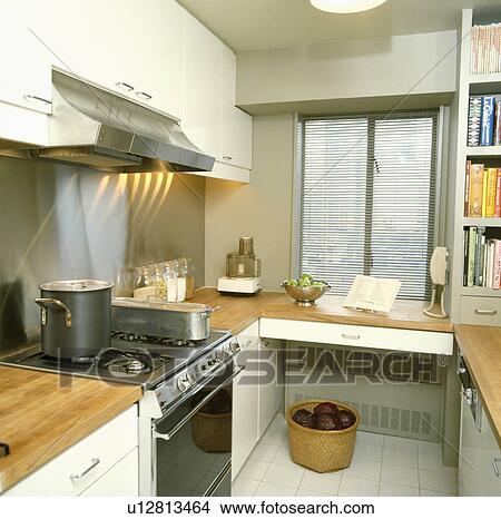 Pan and fishkettle on oven in narrow white kitchen with air conditioning unit below worktop View Large Photo Image Picture - Pan and fishkettle on oven in narrow white kitchen with air conditioning unit below worktop. Fotosearch