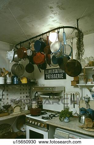 Pans on metal rack above old oven in dilapidated basement kitchen View Large Photo Image Stock Image - Pans on metal rack above old oven in dilapidated basement kitchen. Fotosearch