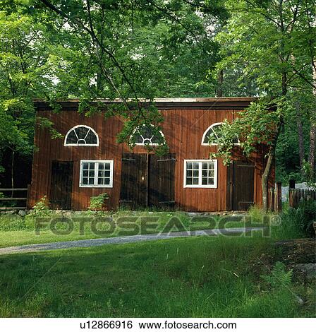 Stock Photograph - Path through glass to wooden German house in trees. Fotosearch