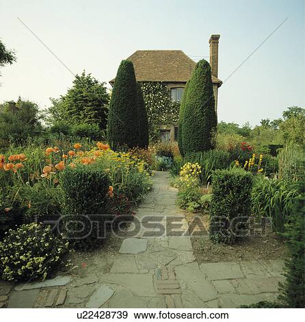Paved path and clipped yew trees in colourful country garden in summer View Large Photo Image Stock Photo - Paved path and clipped yew trees in colourful country garden in summer. Fotosearch