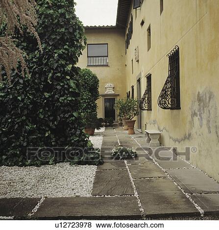 Stock Photo - Paved path beside traditional Italian country house. Fotosearch