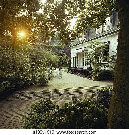 Paved patio in front of large white country house View Large Photo Image Stock Photo - Paved patio in front of large white country house. Fotosearch