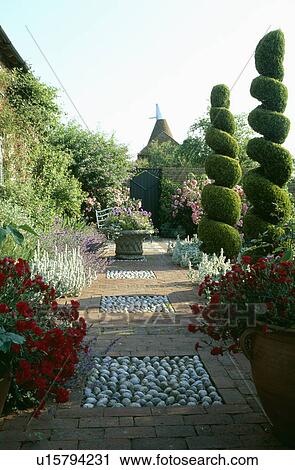 Pebble and brick paving with topiary trees in country garden in summer View Large Photo Image Stock Image - Pebble and brick paving with topiary trees in country garden in summer. Fotosearch