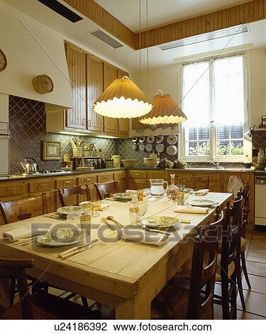 Pendant light above pine table with place settings in traditional neutral kitchen View Large Photo Image Stock Image - Pendant light above pine table with place settings in traditional neutral kitchen. Fotosearch