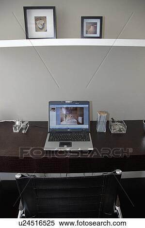 Pictures on shelf above laptop computer on leather desk in modern home office View Large Photo Image Stock Photography - Pictures on shelf above laptop computer on leather desk in modern home office. Fotosearch