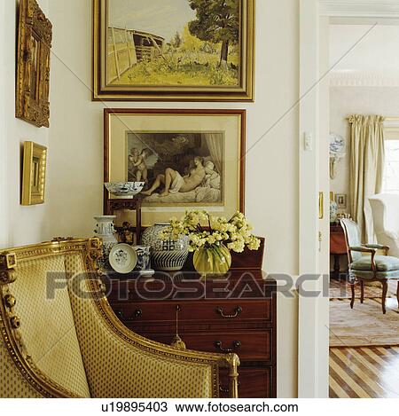 Stock Image - Pictures on wall in above chest of drawers. Fotosearch