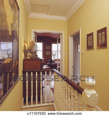 Stock Image - Pictures on walls on yellow townhouse landing. Fotosearch