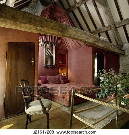Pink fabric walls and drapes and matching bedlinen in small openplan bedroom in barn converesion View Large Photo Image Stock Photo - Pink fabric walls and drapes and matching bedlinen in small openplan bedroom in barn converesion. Fotosearch