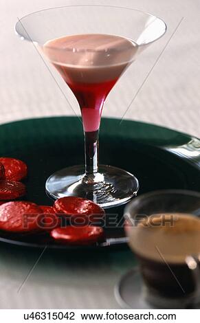 Stock Image - Pink frothy cocktail in elegant glass with chocolate discs.. Fotosearch
