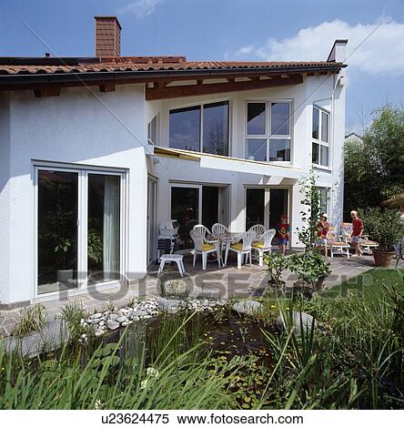 Stock Photography - Pond and patio on front of modern white country house. Fotosearch