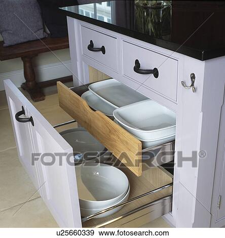 Stock Photo - Pull-out storage drawer with white dishes in modern kitchen. Fotosearch