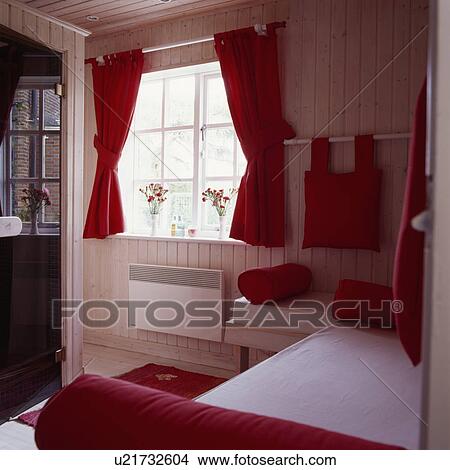 Red curtains and cushions in guest bedroom with wooden walls and ceiling in garden shed View Large Photo Image Picture - Red curtains and cushions in guest bedroom with wooden walls and ceiling in garden shed. Fotosearch