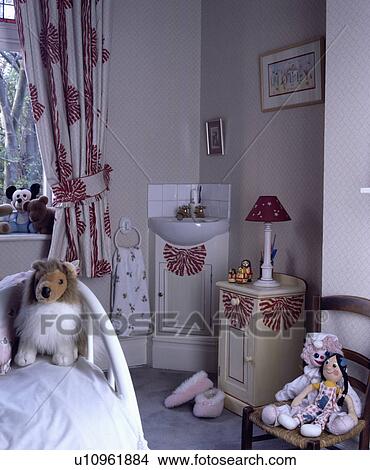 Picture - Red+white hand-stencilled curtains with matching stencil on small cupboard and vanity unit below basin . Fotosearch
