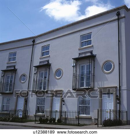 Stock Photo - Rgency-style terraced houses with canopies and ironwook above 1st storey windows. Fotosearch