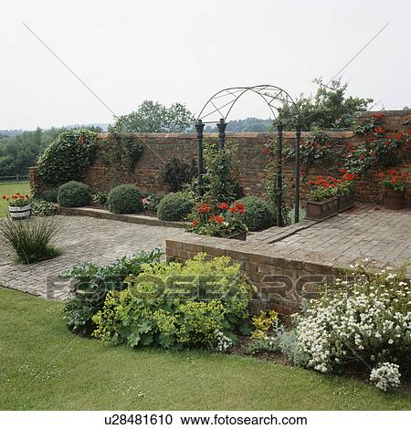 Rose arch and paved patio in country garden in summer View Large Photo Image Stock Image - Rose arch and paved patio in country garden in summer . Fotosearch