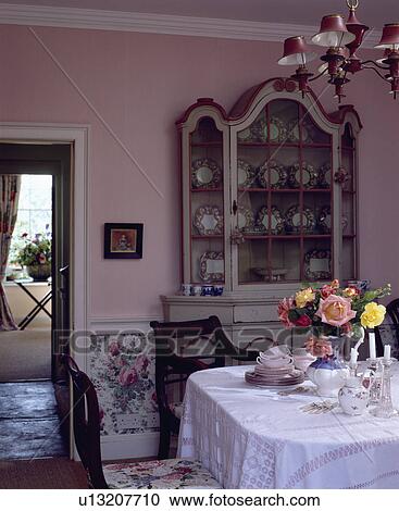 Roses in vase on white tablecloth in pink dining room with antique painted dresser View Large Photo Image Stock Image - Roses in vase on white tablecloth in pink dining room with antique painted dresser. Fotosearch