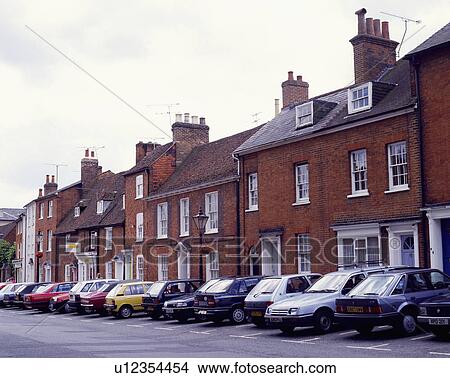 Picture - Row of red brick terraced Georgian and Victorian houses with cars in the street. Fotosearch