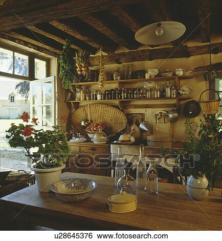 Rustic cottage kitchen with wooden table and shelving View Large Photo Image Stock Photograph - Rustic cottage kitchen with wooden table and shelving. Fotosearch
