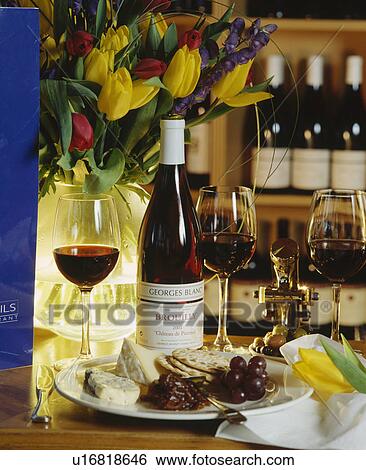 Stock Photograph - Savory lunchtime snack of cheese with grapes and a glass of red wine.. Fotosearch