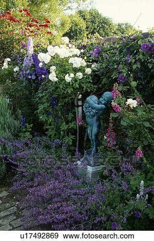 Sculpture in flowering borders in country garden in summer View Large Photo Image Stock Photo - Sculpture in flowering borders in country garden in summer. Fotosearch