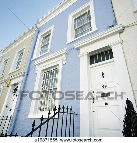 Stock Photography - Security bars on window of traditional Victorian terraced house with white front door. Fotosearch