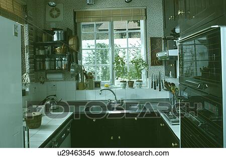 Small kitchen with stainless steel sink below casement window View Large Photo Image Stock Photography - Small kitchen with stainless steel sink below casement window. Fotosearch