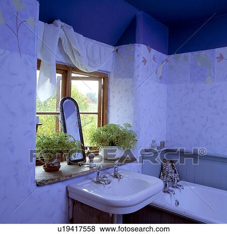 Stock Photo - Small traditional blue cottage bathroom with a stone window ledge . Fotosearch
