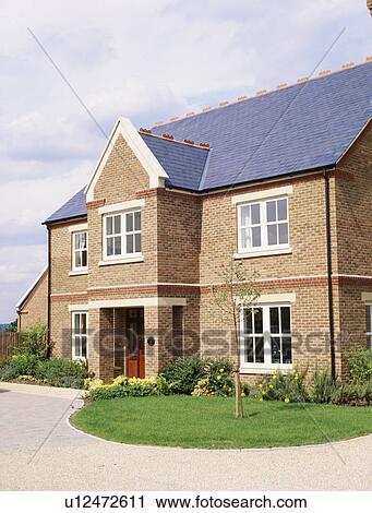 Small tree on circular lawn in front of traditional detached newbuild house View Large Photo Image Stock Image - Small tree on circular lawn in front of traditional detached newbuild house. Fotosearch