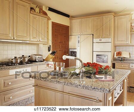 Stainless steel tap and circular sink in island unit with granite worktop in modern pale wood kitchen View Large Photo Image Stock Image - Stainless steel tap and circular sink in island unit with granite worktop in modern pale wood kitchen. Fotosearch
