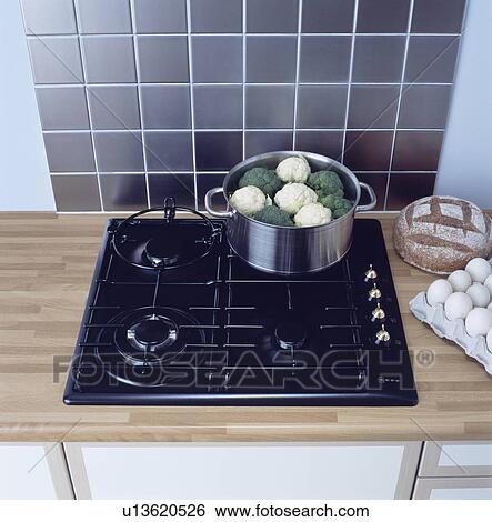 Stainless steel wall tiles above stainless steel pan with vegetables on black gas hob View Large Photo Image Stock Photograph - Stainless steel wall tiles above stainless steel pan with vegetables on black gas hob . Fotosearch