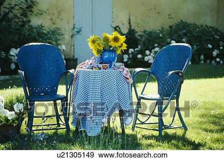 Stock Photo - Still-life of blue garden chairs and checked table cloth. Fotosearch