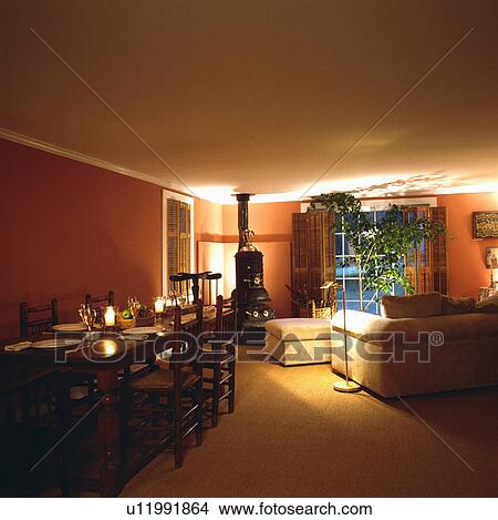 Stove in traditional living and dining room lit at night View Large Photo Image Picture - Stove in traditional living and dining room lit at night. Fotosearch