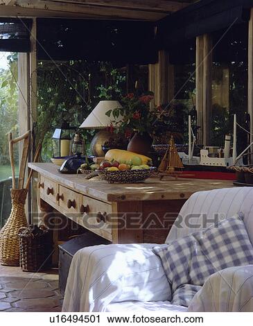 Striped white throw on armchair beside antique pine table in cottage living room View Large Photo Image Stock Image - Striped white throw on armchair beside antique pine table in cottage living room. Fotosearch