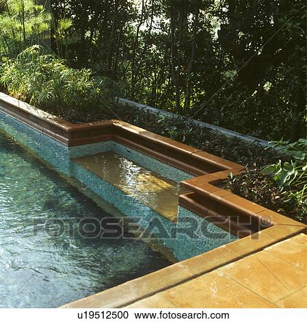 Stock Image - Swimming pool in Italian country garden. Fotosearch