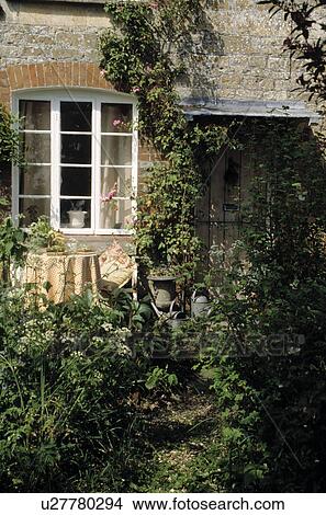 Picture - Table and chairs in front of window in country cottage. Fotosearch