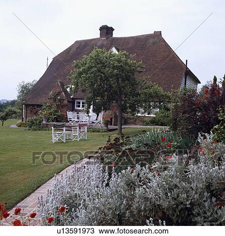 Table and chairs on lawn in country garden in summer View Large Photo Image Stock Image - Table and chairs on lawn in country garden in summer. Fotosearch